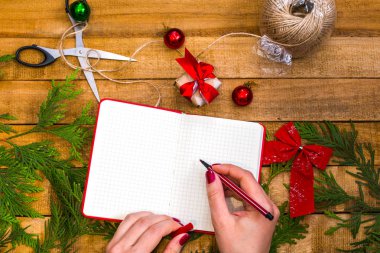 kadınların elleri bir not defterine yazıyor. Noel ve yeni yıl geri