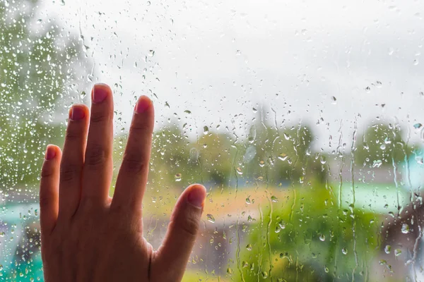 Hand auf das regnerische Glas in Nahaufnahme — Stockfoto