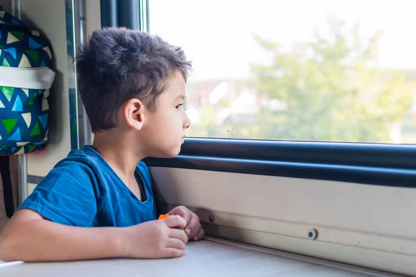 Шестилетний мальчик, путешествующий на поезде. выглядывает в окно — стоковое фото