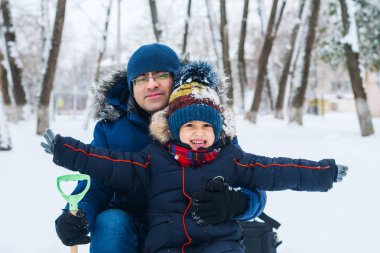 Neşeli çocuk kışın babamla yürüyüşe çıktı.