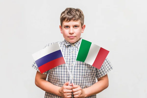 Nastolatek chłopiec posiada flagi Rosja i Włochy — Zdjęcie stockowe