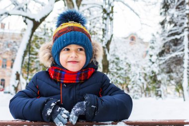 Güzel, gülümseyen bir çocuk. Kışın açık havada 5 yaşında.