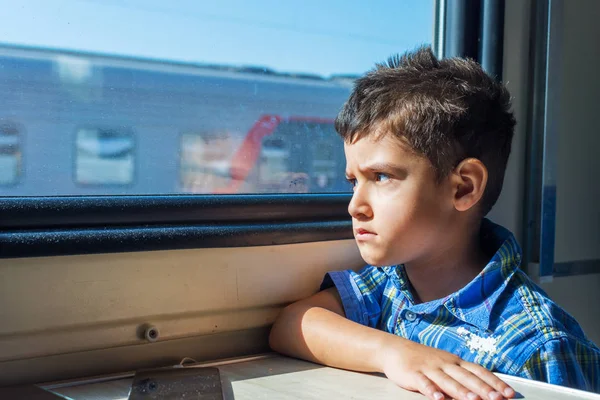 Шестилетний мальчик, путешествующий на поезде. выглядывает в окно — стоковое фото