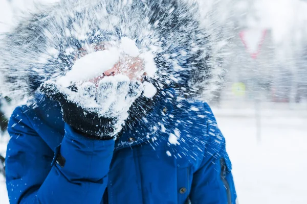 Homem segurando neve em suas mãos e soprando sobre ele — Fotografia de Stock