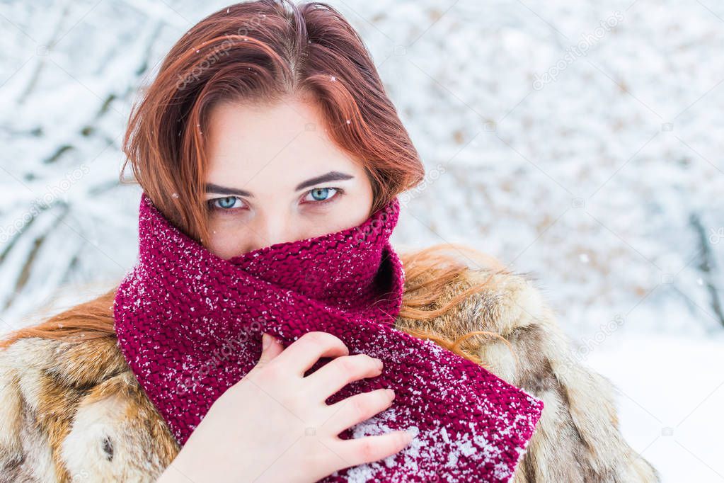 young beautiful woman wrapped in a scarf in winter in outdoors