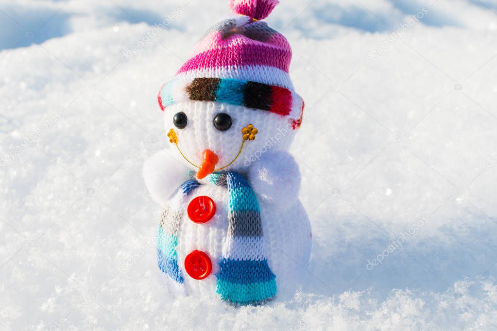 knitted toy snowman in the snow