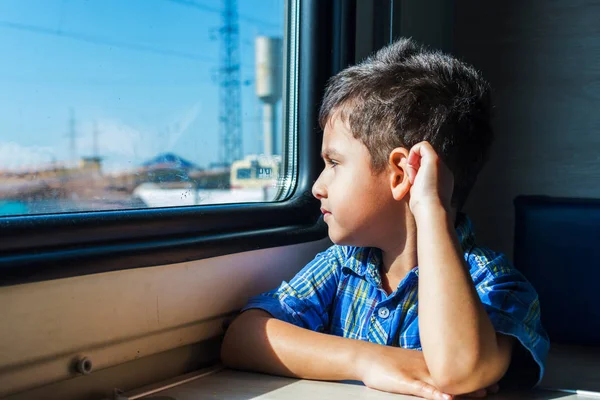 Мальчик 5 лет смотрит в окно. Путешествие на поезде — стоковое фото