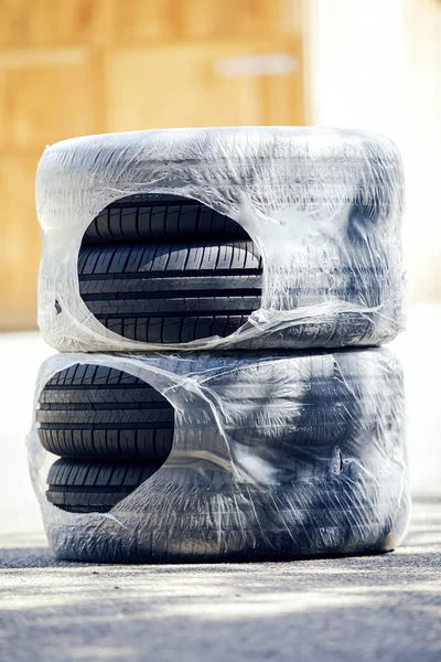 four brand-new summer tires packed in plastic film, ordered online to change tyres
