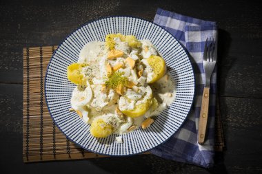 Patates dereotu, krem ve koyu ahşap bir masa geleneksel Avusturya çanak üzerinde mavi bir tabakta haşlanmış yumurta serverd