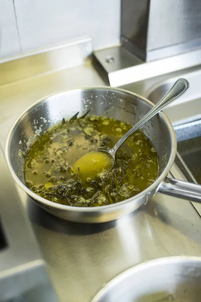 Olive oil and herbs in a stainless steel dish Stock Kép