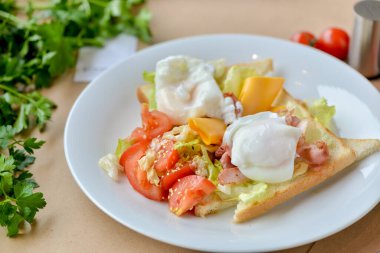 Haşlanmış yumurta, pastırma ve sebzeli sandviç.