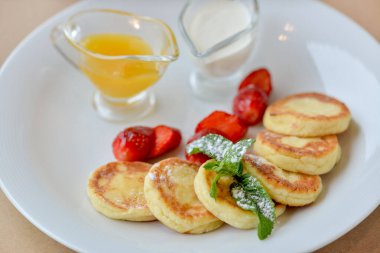 Çilek, meyve reçeli ve ekşi kremayla servis edilen peynirli krep.