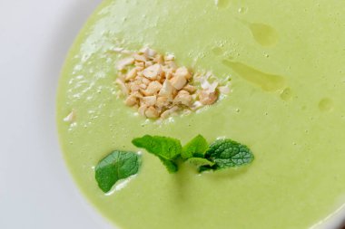 Ispanaklı krema çorbası, doğranmış fındık ve nane yaprağı.