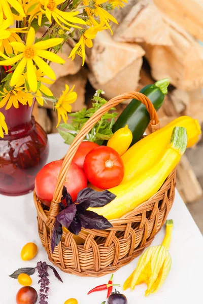 Bouquet de fleurs et panier avec récolte d'automne de légumes de saison — Photo