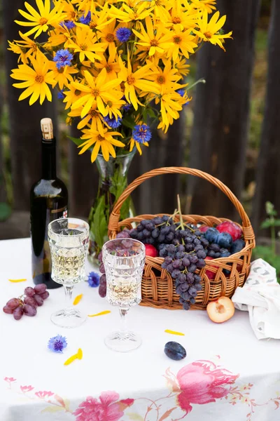 Bouquet de fleurs, vin, verres et raisins sur fond de vieille clôture — Photo