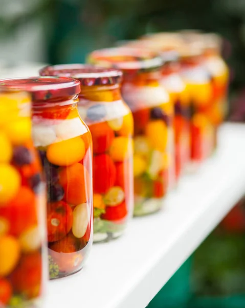 Latas con tomates cherry enlatados en la mesa —  Fotos de Stock
