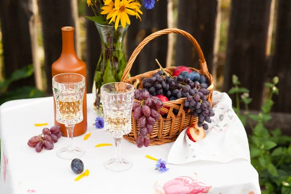 Bouquet de fleurs, vin, verres et raisins sur fond de vieille clôture — Photo