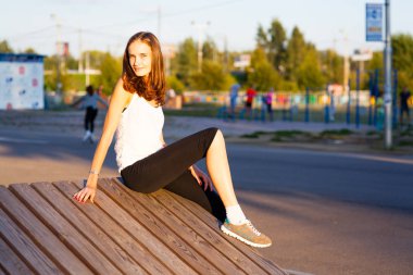 Güzel kız yaz parkında bankta oturur