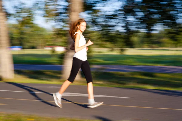 Menina bonita corre rápido na estrada — Fotografia de Stock