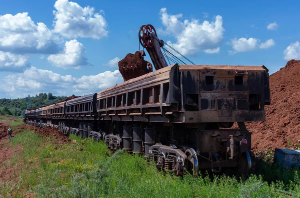 Grävmaskin lastning lera till tåget — Stockfoto
