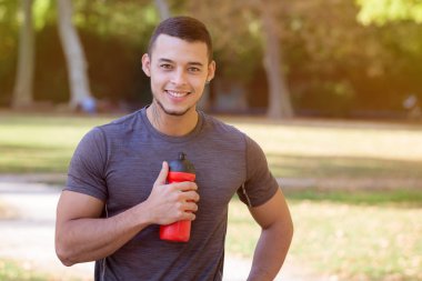 Koşucu su şişesi genç latin adam koşu spor trençalışan