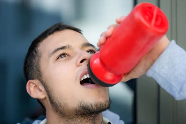 ジョギングスポーツトラを走る飲料水青年ランナー — ストック写真