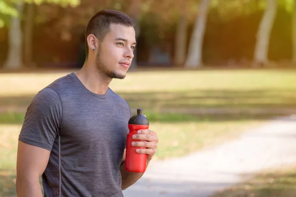 Łaciński człowiek biegacz patrząc myśląc butelka wody Bieganie jogging s — Zdjęcie stockowe