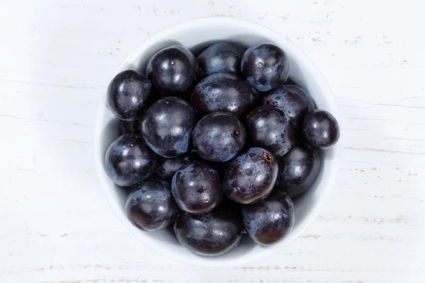 Trauben blaue Früchte Früchte von oben Schüssel Holzbrett — Stockfoto