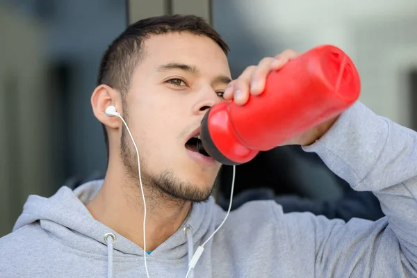 Питьевая вода тренирует фитнес молодого человека зимой — стоковое фото