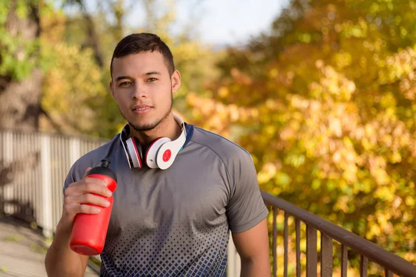 Joven latino bebiendo agua corredor corriendo jogging otoño fal —  Fotos de Stock