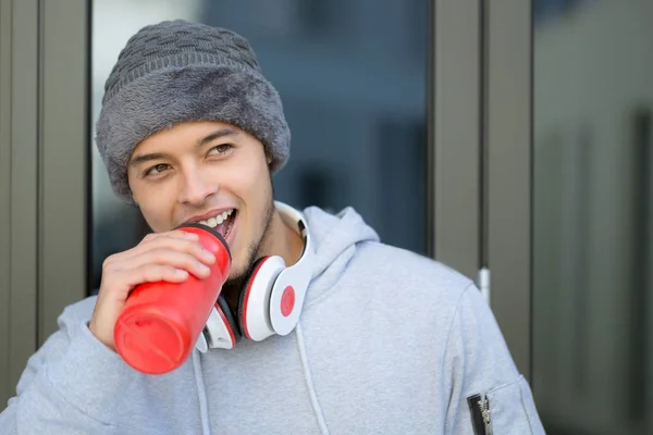 Sonriente joven latino bebiendo agua deportes de invierno entrenamiento fi — Foto de Stock