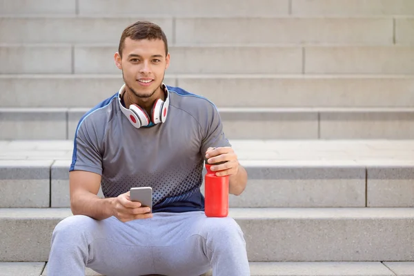 Gülümseyen genç latin adam koşucu koşucu spor spor akıllı telefon co — Stok fotoğraf