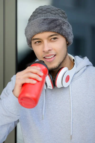 Sorrindo jovem latino homem bebendo água retrato formato inverno sp — Fotografia de Stock