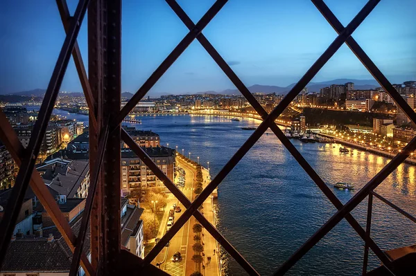 Portekizete, İspanya'da Nervion Nehri üzerinde Vizcaya Köprüsü denilen taşıyıcı köprüden kasabanın akşam görünümü (Puente transportador de Vizcaya) 