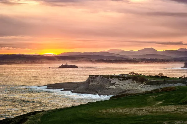 Cabo Belediye Başkanlığı parkında gün doğumu. Santander, Cantabria, Kuzey İspanya Mouro deniz feneri ile ada manzaralı.