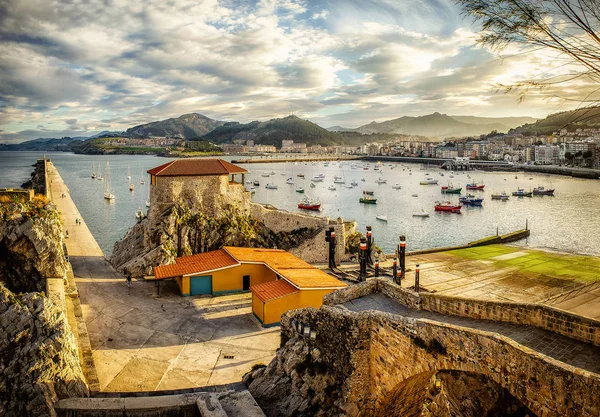 Biscay Körfezi'ndeki Castro Urdiales liman şehrinde altın gün batımı, Kuzey İspanya, Cantabria. 