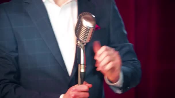 Személy egy retro mikrofonba beszél a színpadon, — Stock videók