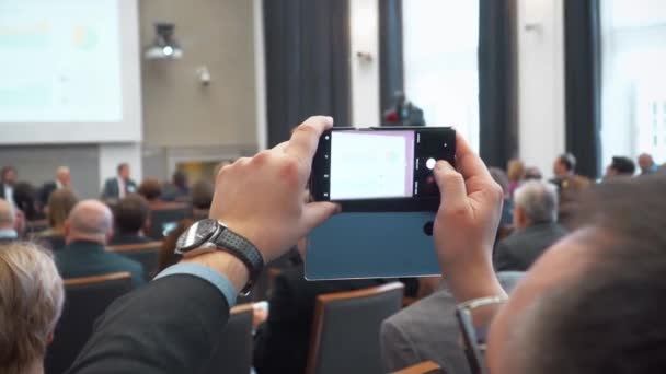 Adam bir konferans sırasında fotoğraf çeker — Stok video