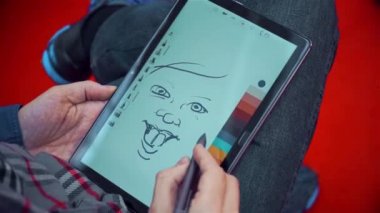 kişi bir tablette karikatürü çizer