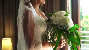 Gelin pencere tarafından bir buket tutar