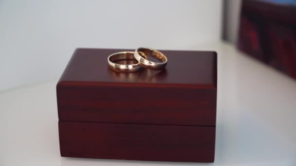 Gold wedding rings on a wooden box — Stock Video