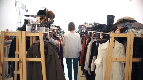 Joven chica elige ropa de segunda mano, reciclaje, salvar el planeta, ecología — Vídeos de Stock