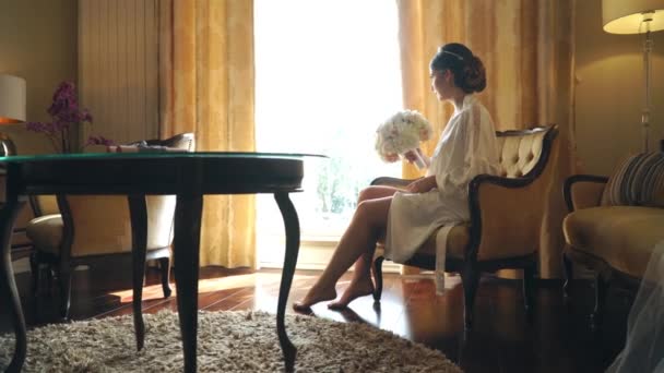 Fiatal menyasszony ült az ablak egy-egy csokor virágot luxus Hotel — Stock videók