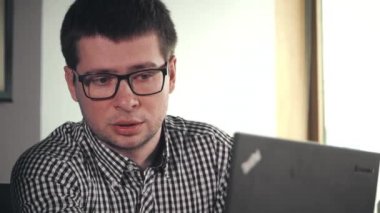 Dizüstü bilgisayar kullanarak gözlüklü adam coworking