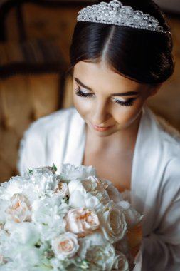 güzel gelin lüks bir otelde çiçekler ile pencerenin yanında oturuyor