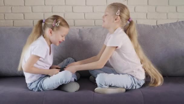Zwillinge nehmen einander das Smartphone weg — Stockvideo