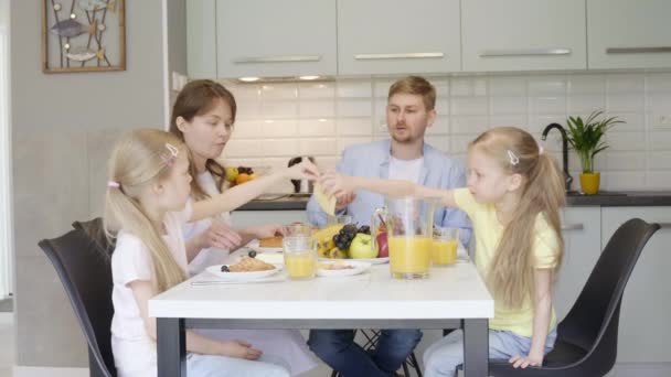 Gelukkige familie praat tijdens het ontbijt — Stockvideo