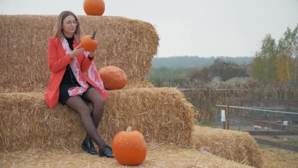 Mladá dívka si vybere dýni na Halloween — Stock video