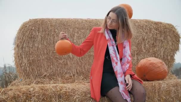 Jong meisje kiest een pompoen voor halloween — Stockvideo