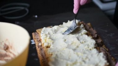 Pembe eldiven ev yapımı kek hazırlama kadınlarla, shes bisküvi ve beyaz peynir ile pasta oluşturmak.. 